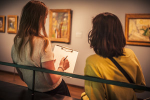 Twee jongeren zijn aan het tekenen bij werken van Vincent van Gogh. Foto: Berbe Rinders