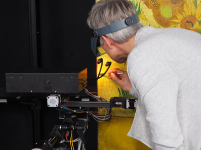 Restaurator Ella Hendriks onderzoekt het schilderij Zonnebloemen