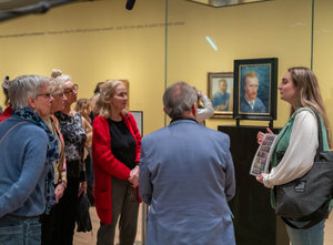 Een groepje senioren kijken tijdens een rondleiding naar een zelfportret van Vincent van Gogh in het Van Gogh Museum.  