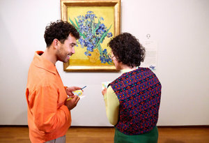 Twee jongeren staan voor het schilderij Irissen van Vincent van Gogh in het Van Gogh Museum en kijken naar elkaars tekening van het schilderij. Foto: Suzanne Karsters