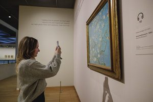 Een meisje fotografeert het schilderij Amandelbloesem van Vincent van Gogh in het Van Gogh Museum. Foto: Les Adu