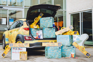 Workshoppakketten in de kofferbak van een Hyundai elektrische auto in Zonnebloemstijl. Foto: Jelle Draper