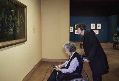 A grandmother in her wheelchair and her grandson before the painting The Potato Eaters. Photo: Maaike Koning