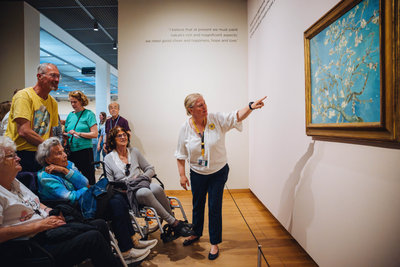 Senioren kijken naar het schilderij Amandelbloesem van Vincent van Gogh tijdens een rondleiding in het Van Gogh Museum. Foto: Jelle Draper