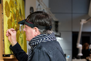 Senior Conservator René Boitelle restores Vincent van Gogh's painting Sunflowers. Photo: Maartje Strijbis