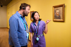 Twee bezoekers luisteren naar de audiotour in het Van Gogh Museum bij een zelfportret van Vincentvan Gogh. Foto: Suzanne Karsters