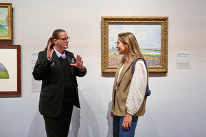 Een beveiliger is in gesprek met een bezoeker in de tentoonstelling Vive l'impressionnisme! in het Van Gogh Museum. Foto: Michael Floor