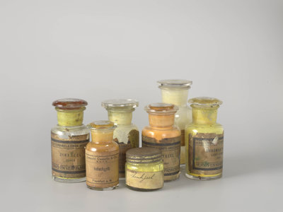 Photograph of seven jars, each containing a different colour of yellow pigment powder, from the collection of the Cultural Heritage Agency of the Netherlands (RCE). Photo: Heleen van Driel