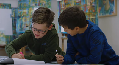 Twee jonge bezoekers werken aan een opdracht met UV licht