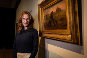 Conservator Lisa Smit voor het schilderij Mest verspreidende boer van Jean-François Millet