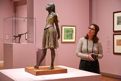 A woman is listening to the audio guide while looking at the sculpture Petit danseuse de quatorze ans by Degas in the exhibition Vive l'impressionnisme! at the Van Gogh Museum. Photo: Michael Floor