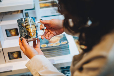 A visitor holds a Van Gogh mug in the Van Gogh Museum shop. Photo: Jelle Draper