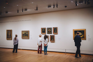 Bezoekers in het Van Gogh Museum kijken naar de schilderijen die Vincent van Gogh maakte van het boerenleven in Nuenen. Foto: Jelle Draper