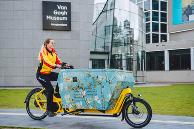 DHL parcel deliverer with her cargo bike on the Museumplein in front of the Van Gogh Museum. Photo: Jelle Draper