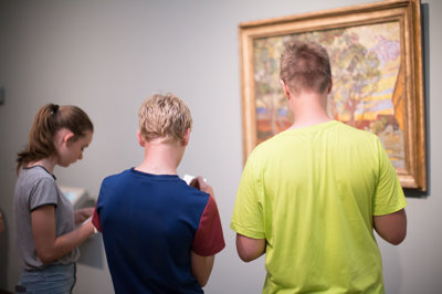 Twee jongens en een meisje maken opdrachten bij het schilderij De tuin van de inrichting (1889) van Vincent van Gogh. foto: Brenda Roos 