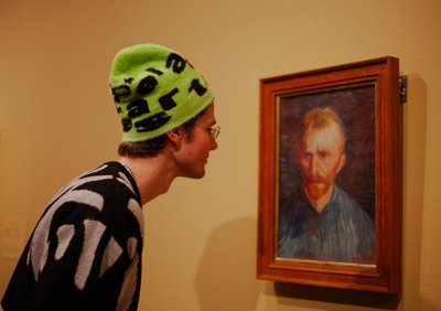 Een jongere kijkt naar een zelfportret van Vincent van Gogh in het Van Gogh Museum.
