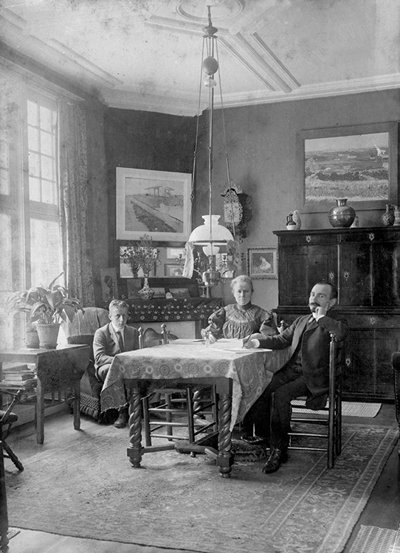 Foto van Jo Bonger in haar zitkamer, omgeven door schilderijen van Vincent