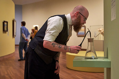 Bezoeker in de tentoonstelling 'Geel. Meer dan Van Goghs lievelingskleur' ruikt aan een van de geuren die speciaal voor de tentoonstelling zijn ontwikkeld door geurexperts van Robertet. Foto: Michael Floor