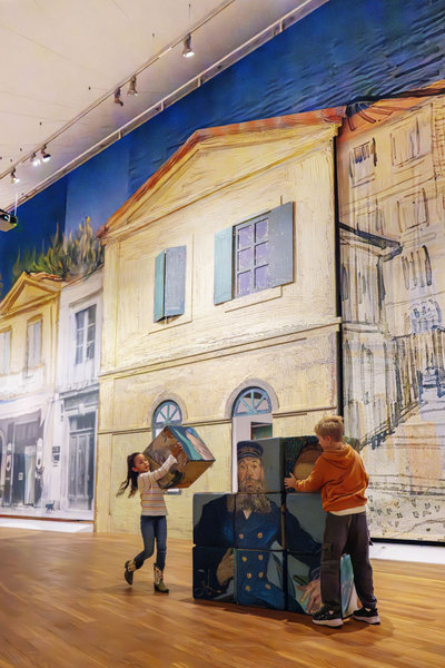 Bij een levensgrote versie van het Gele Huis spelen twee kinderen met puzzelblokken van het schilderij van de postbode Roulin. Foto: Anke van der Meer 