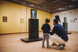 Een vader kijkt met zijn zoontje en dochter naar een zelfportret van Vincent van Gogh in het Van Gogh Museum. Foto: Jelle Draper