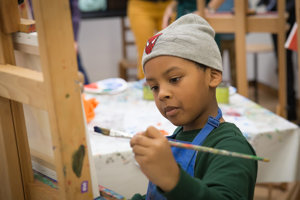 Een jongetje aan het werk tijdens een schilderworkshop