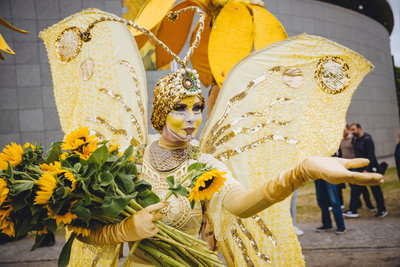 A street theatre artist dressed as a butterfly  is handing out sunflowers at the Sunflower Art Festival to celebrate the Van Gogh Museum's 50th anniversary on 2 June 2023. Photo: David Stegenga / Jelle Draper