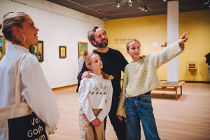 A fahter and his two daughters participate in a family tour at the Van Gogh Museum.  The eldest daughter points to a painting out of shot. Photo: Jelle Draper