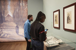 Twee bezoekers kijken naar Van Goghs tekeningen in de tentoonstelling over De aardappeleters. Foto: Maaike Koning
